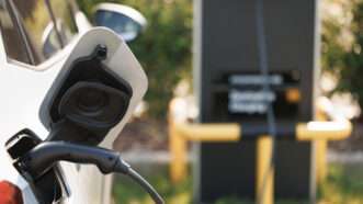 Close-up of an electric vehicle plugged in to charge. | Mykola Pokhodzhay | Dreamstime.com