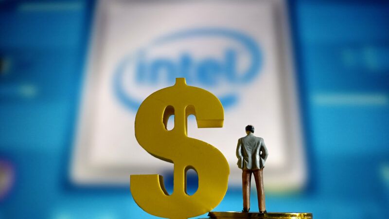 An Intel logo in the background with a gold dollar sign and a figurine in the foreground | zumaamericasforty850847 (RM)
